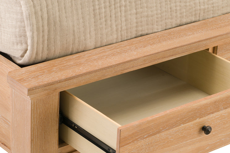 Wooden bed frame with an open drawer, showing a beige cushioned headboard.